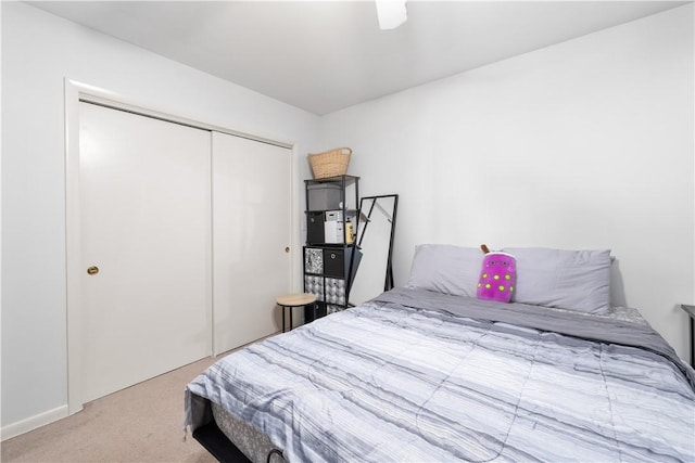 carpeted bedroom with ceiling fan and a closet