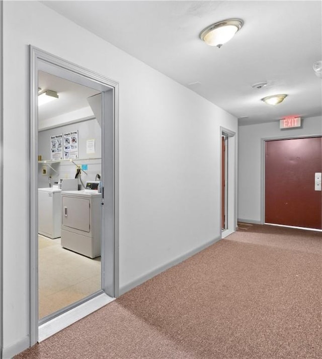 corridor featuring separate washer and dryer and light carpet