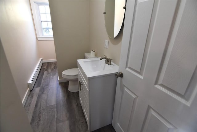 bathroom with baseboards, toilet, a baseboard radiator, wood finished floors, and vanity