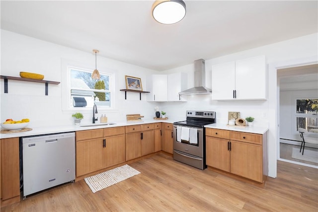 kitchen featuring dishwashing machine, wall chimney range hood, stainless steel electric range, sink, and white cabinetry