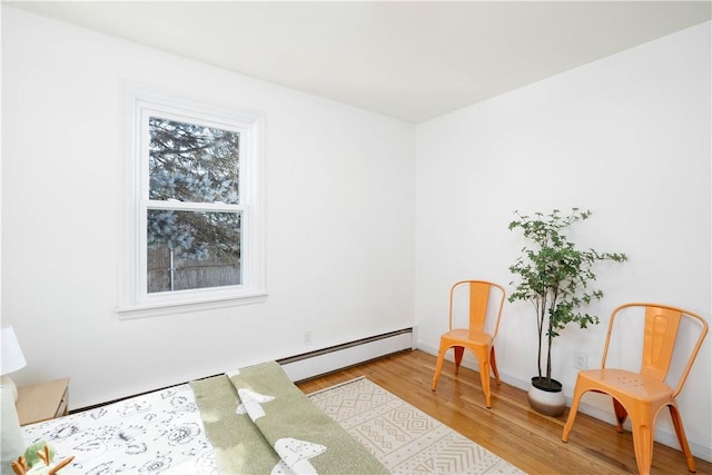 living area with a baseboard radiator and light hardwood / wood-style floors