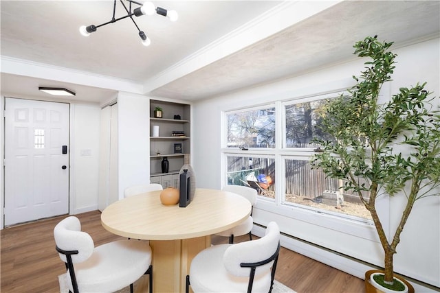 dining area featuring crown molding, hardwood / wood-style floors, and baseboard heating