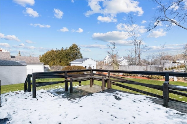 snow covered deck featuring a yard