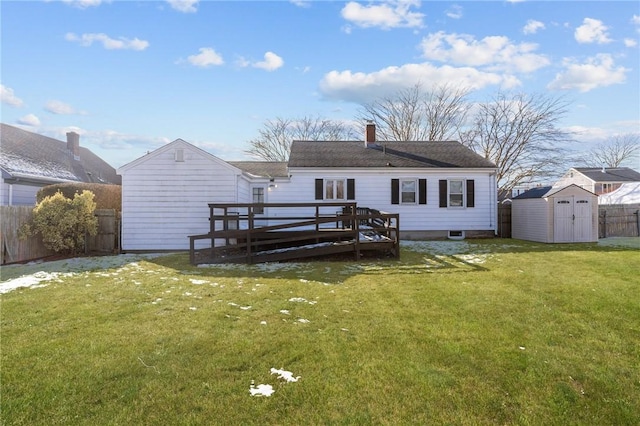 back of property featuring a wooden deck, a yard, and a storage unit