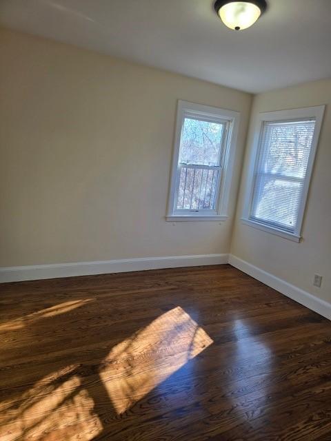 spare room with dark hardwood / wood-style flooring