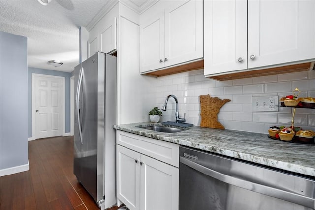 kitchen featuring dark hardwood / wood-style floors, white cabinetry, sink, stainless steel appliances, and light stone countertops