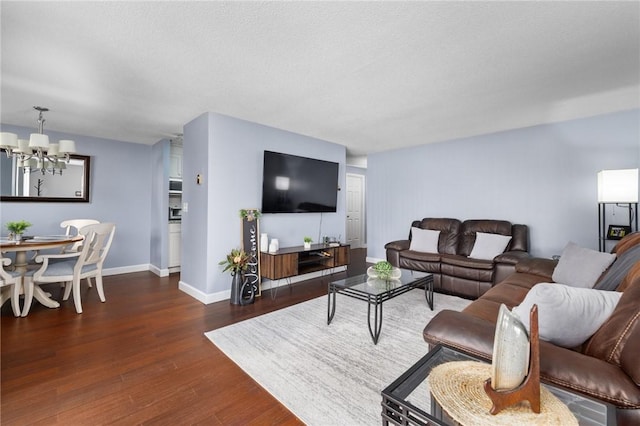 living room featuring dark hardwood / wood-style flooring, a textured ceiling, and a notable chandelier