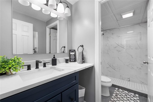 bathroom featuring tiled shower, vanity, toilet, and a notable chandelier