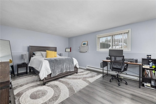 bedroom featuring baseboard heating and light hardwood / wood-style flooring