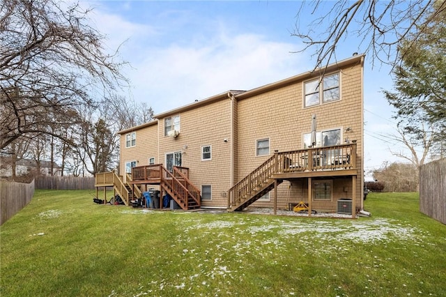 back of house featuring cooling unit, a wooden deck, and a lawn