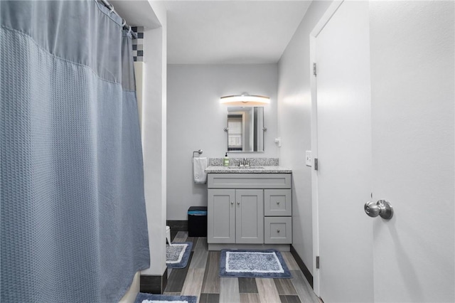 bathroom featuring hardwood / wood-style flooring, vanity, and curtained shower