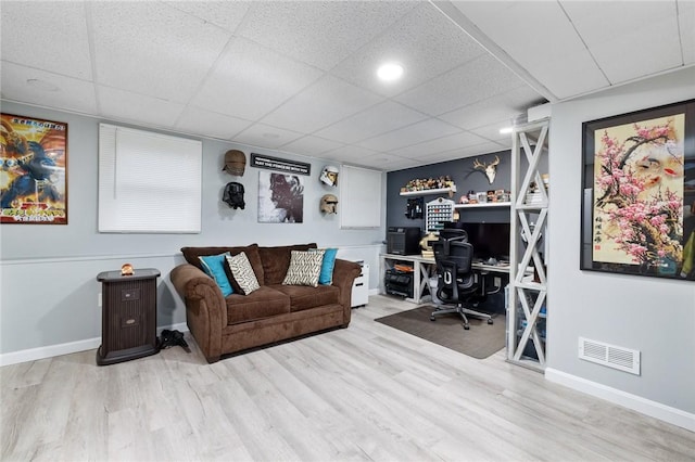 office space featuring a drop ceiling and light hardwood / wood-style flooring