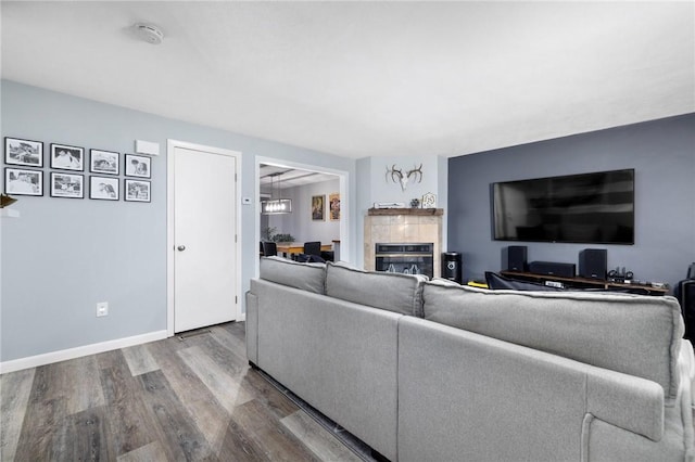 living room with wood-type flooring and a tile fireplace