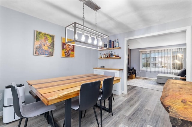 dining area featuring bar area and light hardwood / wood-style floors