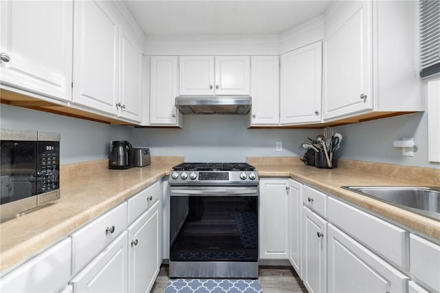 kitchen with appliances with stainless steel finishes, sink, and white cabinets