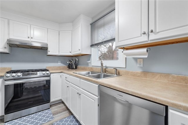 kitchen featuring appliances with stainless steel finishes, sink, hardwood / wood-style floors, and white cabinets