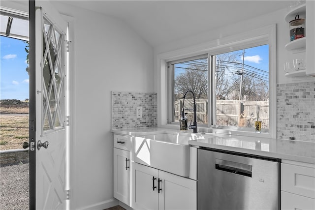 kitchen featuring lofted ceiling, sink, dishwasher, decorative backsplash, and white cabinets