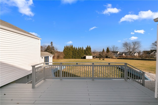 wooden terrace featuring a shed and a lawn