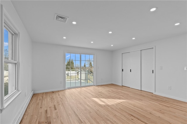 empty room featuring a baseboard heating unit and light hardwood / wood-style floors