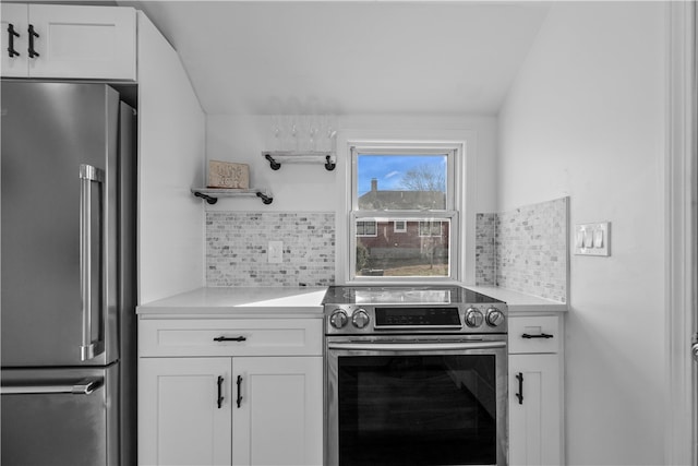 kitchen featuring stainless steel appliances, white cabinetry, and backsplash