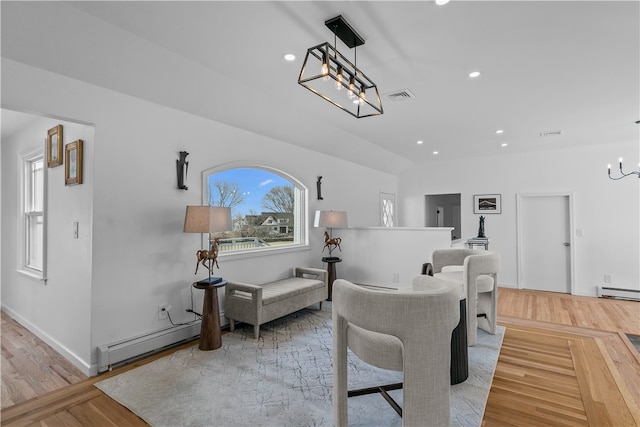 interior space with an inviting chandelier, a baseboard radiator, and light hardwood / wood-style floors