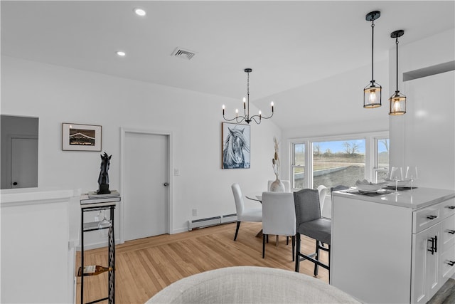 dining area featuring baseboard heating, lofted ceiling, a chandelier, and light wood-type flooring