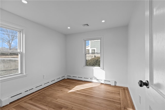 unfurnished room featuring wood-type flooring and baseboard heating