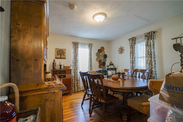 dining room with hardwood / wood-style floors and a textured ceiling