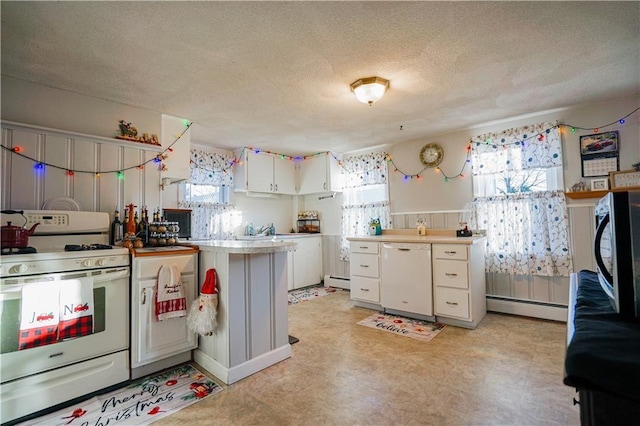 kitchen with a baseboard radiator, a textured ceiling, white cabinets, and white appliances