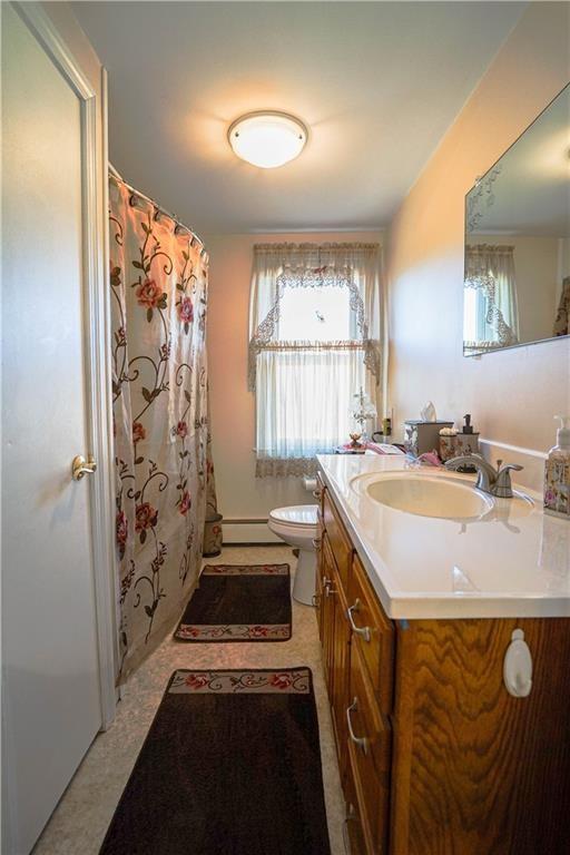 bathroom featuring vanity, a baseboard radiator, and toilet