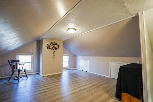 additional living space with wood-type flooring and lofted ceiling