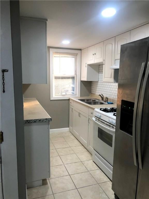 kitchen with sink, white range with gas stovetop, white cabinetry, stainless steel fridge with ice dispenser, and decorative backsplash