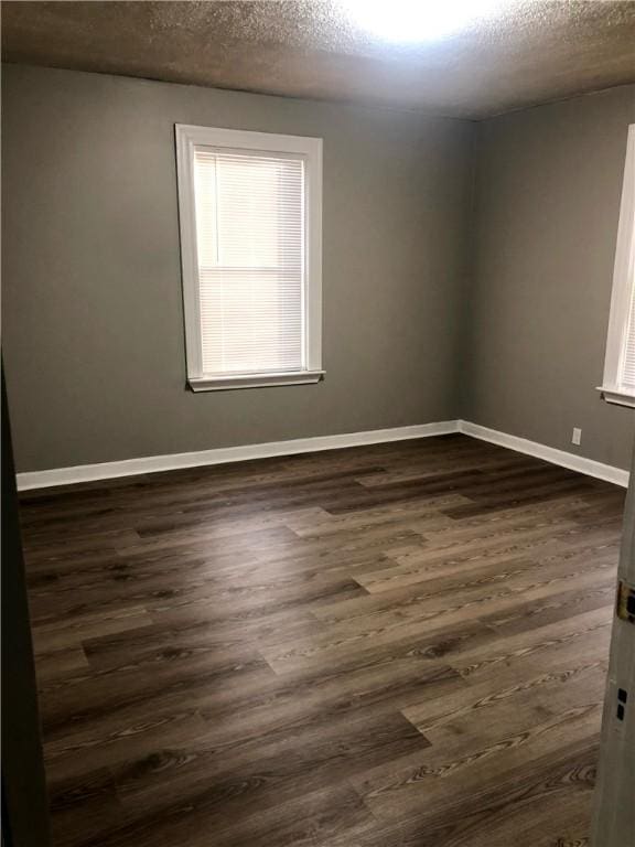 spare room with dark wood-type flooring and a textured ceiling