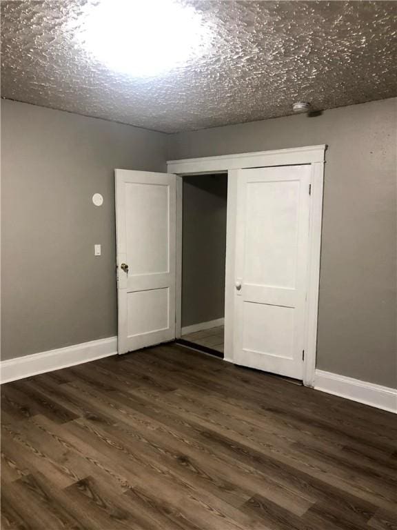 interior space with dark hardwood / wood-style floors, a textured ceiling, and a closet