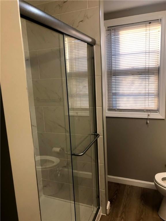 bathroom with an enclosed shower, hardwood / wood-style floors, and toilet