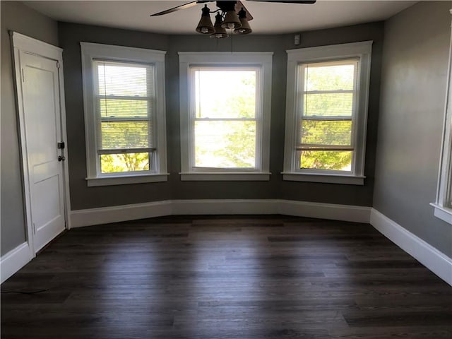 unfurnished room featuring dark wood-type flooring and ceiling fan