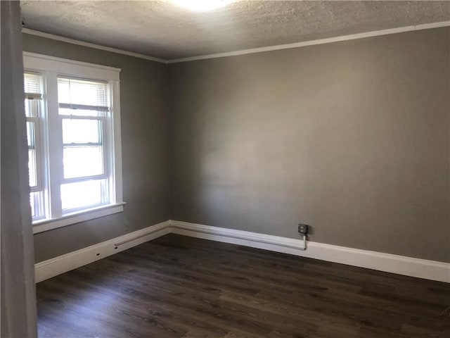 spare room featuring dark wood-type flooring, ornamental molding, and a textured ceiling