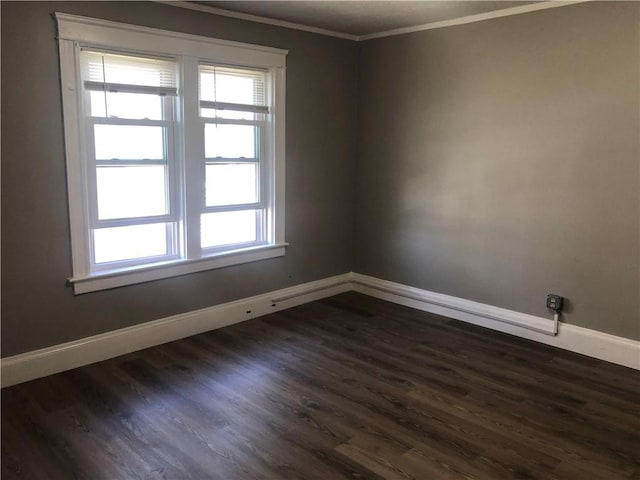 empty room featuring ornamental molding and dark hardwood / wood-style floors