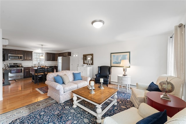 living room featuring wood-type flooring and a baseboard heating unit