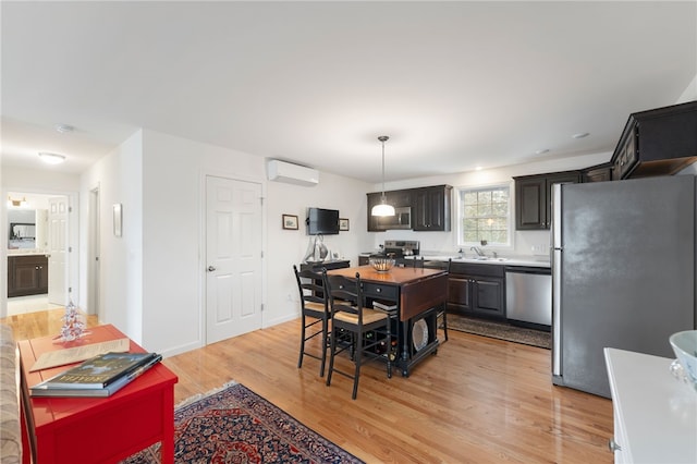 dining space with sink, a wall mounted air conditioner, and light wood-type flooring