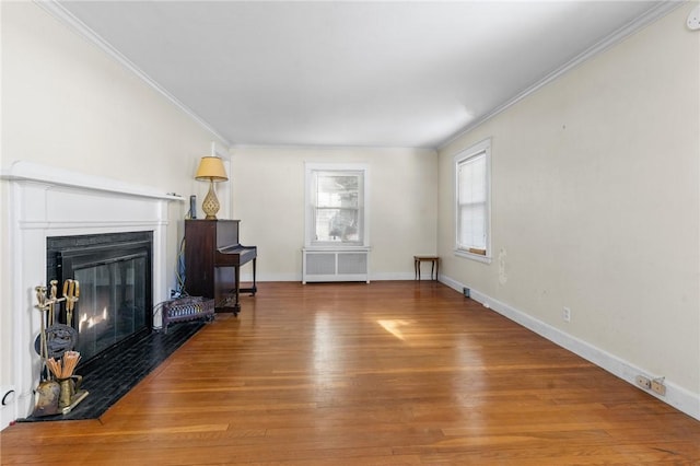 living room with hardwood / wood-style floors, crown molding, and radiator heating unit