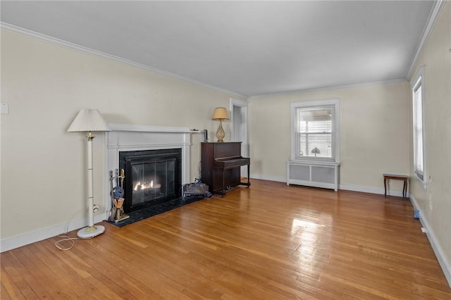 unfurnished living room with crown molding, radiator, and hardwood / wood-style floors