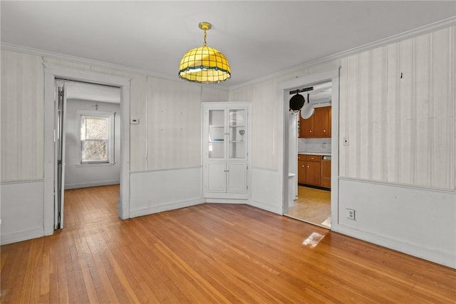 empty room featuring ornamental molding and light hardwood / wood-style floors