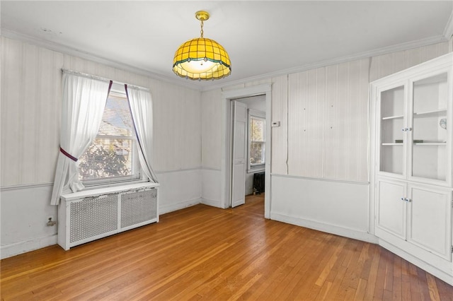 spare room with radiator, crown molding, and hardwood / wood-style floors