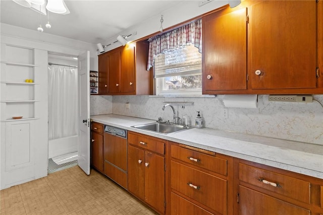 kitchen with sink, paneled dishwasher, and decorative backsplash