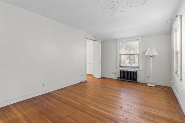 unfurnished living room with radiator and light hardwood / wood-style flooring