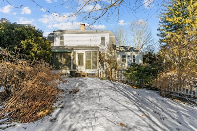 view of snow covered back of property