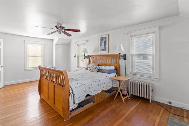 bedroom with radiator, vaulted ceiling, hardwood / wood-style floors, and ceiling fan