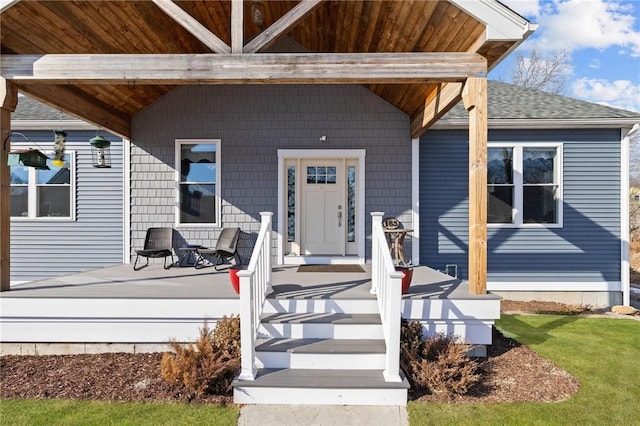 property entrance featuring roof with shingles and covered porch