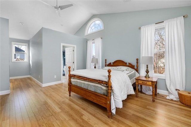 bedroom with multiple windows, lofted ceiling, and light hardwood / wood-style floors